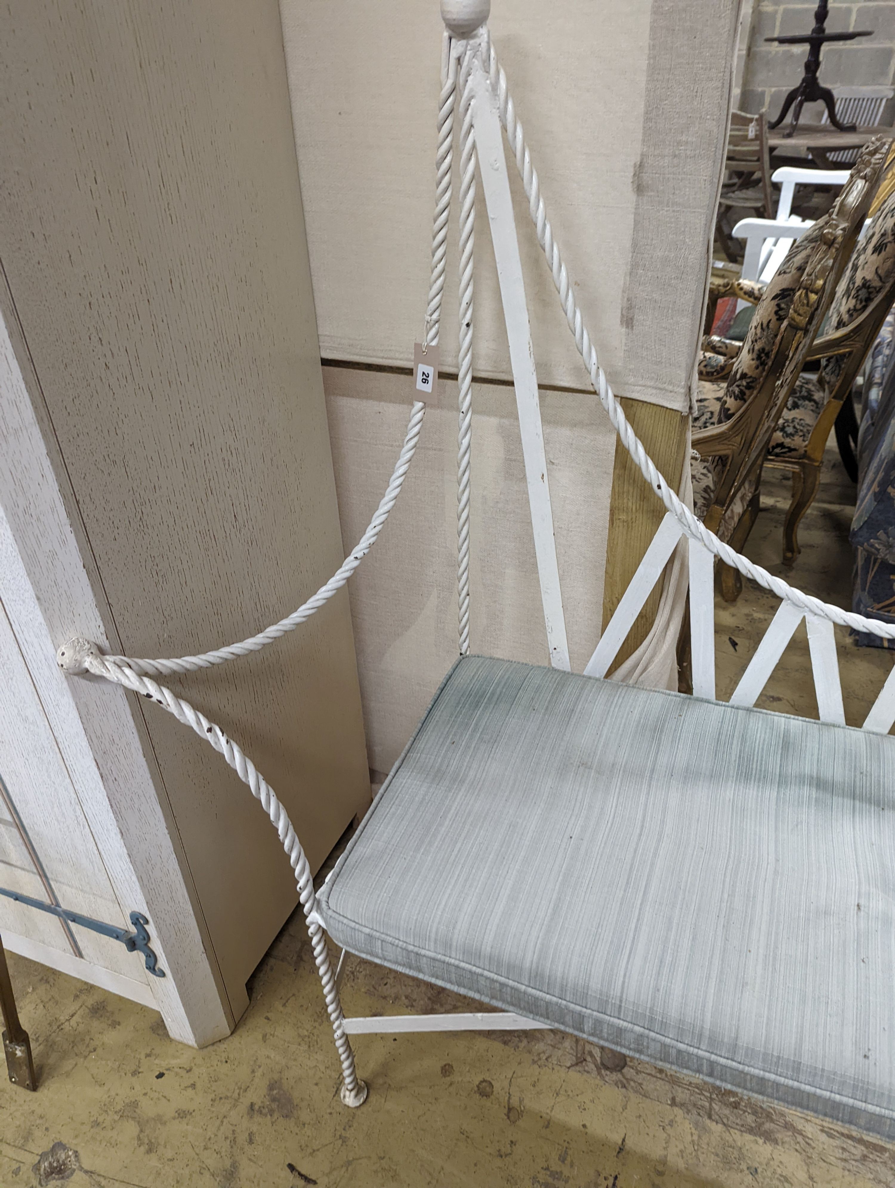 A wrought iron 'rope twist' seat with squab cushion, length 140cm, depth 54cm, height 132cm